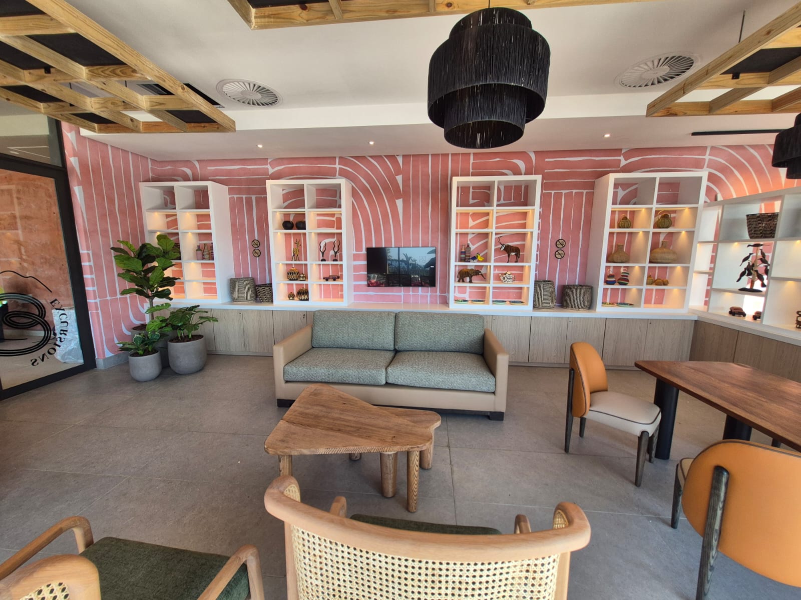Excursions lounge with lit display cases, banquette seating and a woven pendant